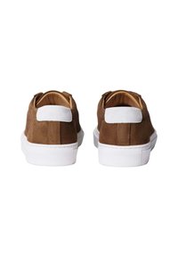 Baskets en daim marron avec une semelle en caoutchouc blanche, présentant une texture et un onglet de talon blanc contrastant.