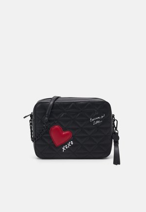 Borsa a tracolla nera trapuntata con un dettaglio a cuore rosso, testo bianco "Credi nell'amore" e "xoxo", dotata di tracolla a catena staccabile e nappina.