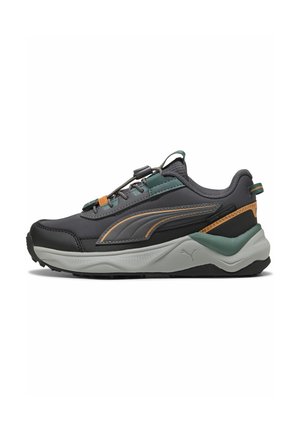 Sort og grøn Puma-sneaker med grå sål, orange accenter, polstret hæl og trækflig på hvid baggrund, vist fra siden.