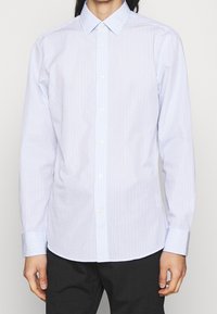 Camicia button-up a righe blu chiaro e bianco con colletto, maniche lunghe e chiusura con bottoni, realizzata in un tessuto liscio, con polsini che presentano righe abbinate.