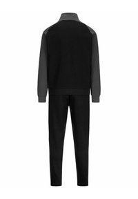 Completo tuta nera con giacca zip-up a collo alto e maniche con accenti grigi, abbinato a pantaloni neri tapered coordinati.