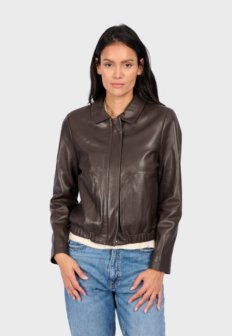 Veste cropped en cuir marron avec un col, présentant deux poches avant et une taille côtelée. Texture lisse et design ajusté.