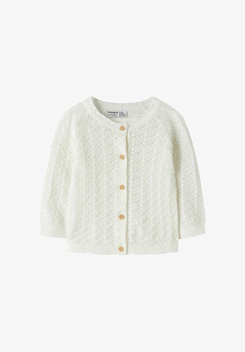 Cardigan bébé blanc en tricot avec manches longues, col rond et cinq boutons en bois sur le devant.
