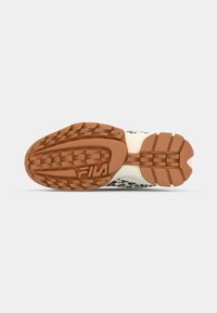 Sport shoe sole with patterned grip, primarily brown rubber. Features textured segments and a logo embossed at the heel.