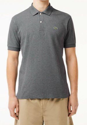 Graues Polohemd aus weichem Material, mit einem Kragen, drei Knöpfen und einem kleinen grünen Krokodil-Logo auf der linken Brust.