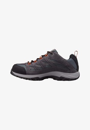 Zapato de senderismo gris con materiales de malla y ante, presenta acentos naranjas, una suela acolchada y una puntera reforzada para mayor durabilidad.