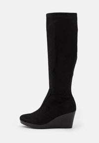 Bottes compensées noires en faux suède. Design montant jusqu'aux genoux avec une texture lisse et un bout arrondi. Aucun élément métallique ni motif visible.