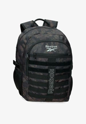 Mochila Reebok en camuflaje negro y gris con múltiples compartimentos con cremallera, bolsillos laterales de malla, correas acolchadas y logo de la marca en el frente.