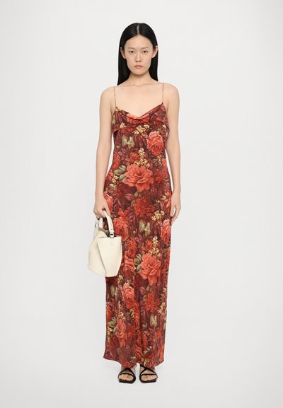 Red floral maxi dress with thin adjustable straps, a cowl neckline, and a fitted silhouette. Worn with a white handbag and black sandals.