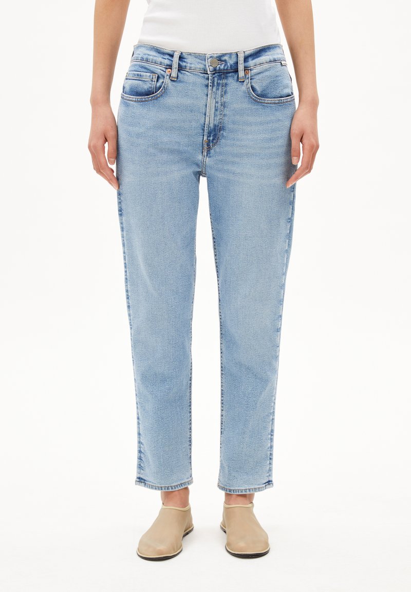 Jeans en denim bleu clair avec une coupe droite, cinq poches et une fermeture à bouton. Présente des zones délavées et de subtils détails de couture.