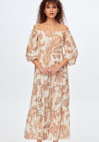 Cremefarvet og rustfarvet, blomstertrykt off-the-shoulder maxi kjole med pufærmer, lagdelt design og afslappet pasform.
