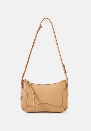 Sac à bandoulière en cuir beige avec sangle ajustable, fermeture éclair et détails subtils de couture courbée sur fond uni.