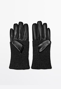 Zwarte leren handschoenen met geribde gebreide manchetten, voorzien van een gladde textuur en een ontwerp met vijf vingers. Accentdetails in contrasterend materiaal bij de pols.