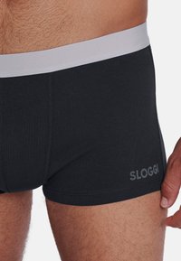 Sloggi svarta bomullshorts med grå elastisk midja, med en mjuk textur och en liten logo på sidan.