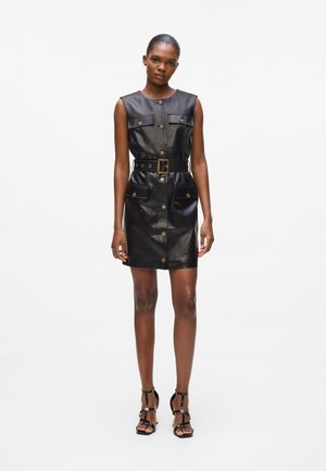 Black leather dress with sleeveless design, round neckline, button front, and two front pockets. Includes a matching belt, flat buttons, and a fitted shape.