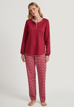 Maglietta rossa a maniche lunghe con colletto a quadri abbinata a pantaloni del pigiama a scacchi rossi e bianchi. Materiale in cotone morbido, design leggero.