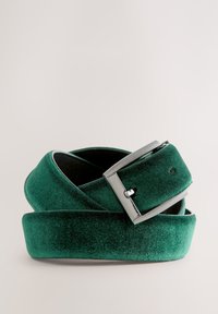 Cintura in velluto verde con fibbia rettangolare in argento. La texture è morbida, con una finitura liscia e un design resistente.