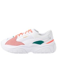 Weiße Sportschuhe mit pinkem Wildleder und tealfarbenen Akzenten. Sie verfügen über orange Schnürsenkel, ein strukturiertes Obermaterial und eine klobige Sohle mit Profilmuster.