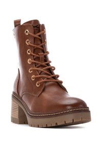 Botín de cuero marrón hasta el tobillo con diseño de cordones, ojales dorados y un panel lateral texturizado. Cuenta con un tacón cuadrado y suela robusta.