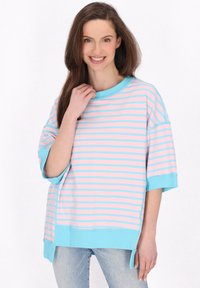 Randig oversized t-shirt i rosa och ljusblå, med rundad halsringning och korta ärmar, samt sidokilar vid nederkanten.