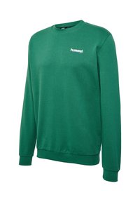 Grøn crewneck sweatshirt med lange ærmer og hvidt "hummel" logo på venstre bryst, med ribbet kant ved ærmer og bund.