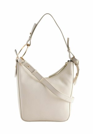 Cream-colored leather shoulder bag with adjustable strap, gold ring detail, and zipper closure on top.