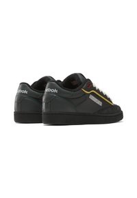 Black leather sneakers with textured accents, white laces, and colorful side details in yellow and teal. Features a rubber outsole and logo.