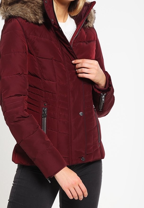 Vinröd vadderad vinterjacka med pälskant på huvan, med dragkedjeförsedda sidofickor och knappstängning framtill med horisontella sömndetaljer.