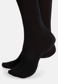 Schwarze Socken aus einem glatten, dehnbaren Stoff, mit einem schlichten Design, nahtloser Zehenpartie und einem gerippten Bündchen.