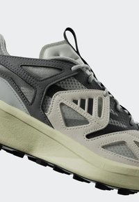 Lichte sneakers met een combinatie van grijze mesh en suède, en een dikke roomkleurige zool. Textuuraccenten en veters zorgen voor ondersteuning.