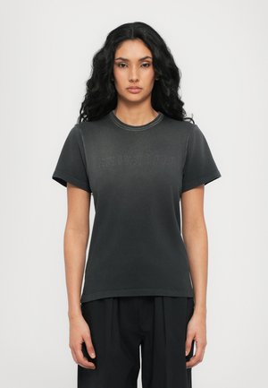 Black cotton t-shirt with short sleeves, round neckline, and embossed "HELMUT LANG" text on the front. Smooth texture.