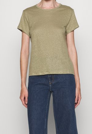 Olivengrøn kortærmet t-shirt lavet af blødt stof. Slim-fit design, rund halsudskæring og subtil tekstur. Kombination med mørkeblå jeans.