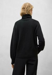 Schwarzer Rollkragenpullover mit geripptem Kragen und Saum, locker geschnitten mit langen Ärmeln, aus einem weichen, strukturierten Material gefertigt.