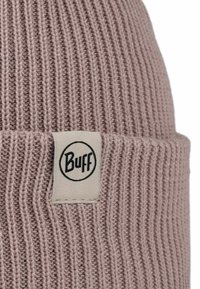 Pink knitted beanie made from ribbed fabric, featuring a woven tag with a circular black logo.