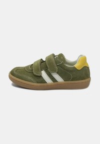 Sneaker verde in suede con strisce bianche, fibbie in Velcro e un accentuazione gialla sul tallone. Presenta una suola in gomma marrone texturizzata.