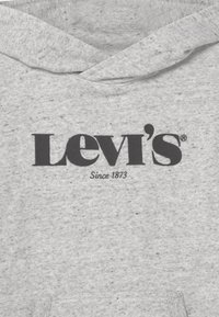 Felpa grigia con logo nero "Levi's Since 1873" centrato sul petto, che mostra il cappuccio piegato e la morbida texture del tessuto.