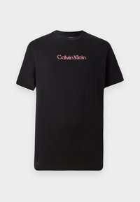 Black short-sleeve t-shirt made of cotton, featuring a central Calvin Klein logo in red and white, with a crew neck and relaxed fit.