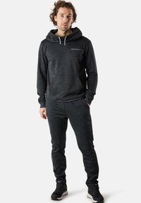 Dunkelgrauer Hoodie mit einer vorderen Tasche, Kordelzug und Logo. Kombiniert mit dunkelgrauen Jogginghosen mit Bündchen. Weicher, strukturierter Stoff.