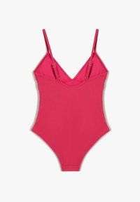 Traje de baño de una sola pieza rosa con tirantes finos, escote en V profundo y tejido elástico. Presenta acentos de hardware circular en tono plateado en las uniones de los tirantes.