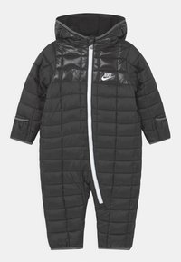 Mono de nieve negro acolchado de Nike para bebés, con capucha, cierre blanco y logo en el pecho, diseñado para el clima frío.