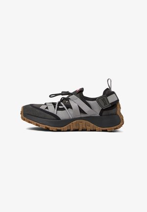 Buty sportowe z czarną i szaro-skalistą cholewką, z elastycznymi paskami, gumową podeszwą z bieżnikiem oraz uchwytem do łatwego zakładania.