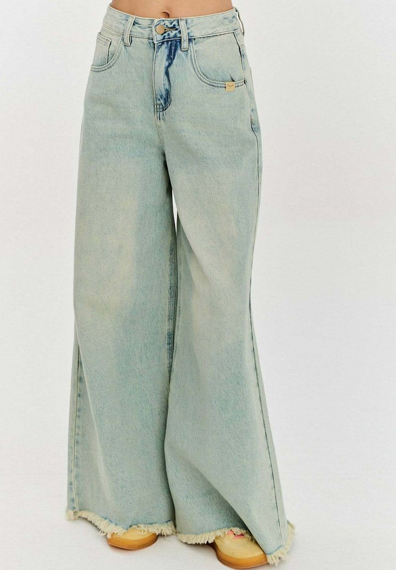 Široké světle modré džínové kalhoty s rozstřiženým lemem, vysokým pasem a jemným efektem vyblednutí na přední straně. Navrženy s předními kapsami a zapínáním na knoflík.