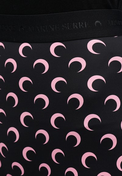 Μαύρο ύφασμα με επαναλαμβανόμενο μοτίβο ρόζ ημισεληνοειδών σχημάτων, με μαύρη ζώνη μέσης που φέρει ανάγλυφο το λογότυπο "MARINE SERRE".