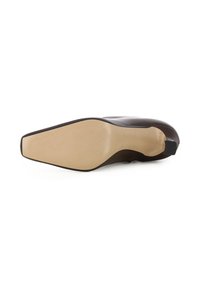 Scarpa in vernice marrone con punta affilata, tacco alto e suola testurizzata. Presenta una finitura liscia e una suola beige a contrasto.