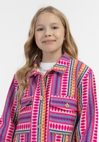 Daugiaspalvis raštuotas švarkas, kuriame derinami rožinės, oranžinės, mėlynos ir žalios spalvos atspalviai, su dviem priekinių kišenėlių ir auksinėmis sagomis.