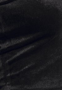 Svart sammetstyg med mjuka veck och en subtil glans, som visar struktur och ljusreflexer.