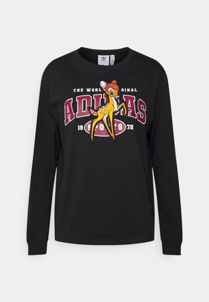 Chemise noire à manches longues avec un grand texte rouge Adidas, un texte blanc plus petit et un dessin animé coloré de cerf au centre.