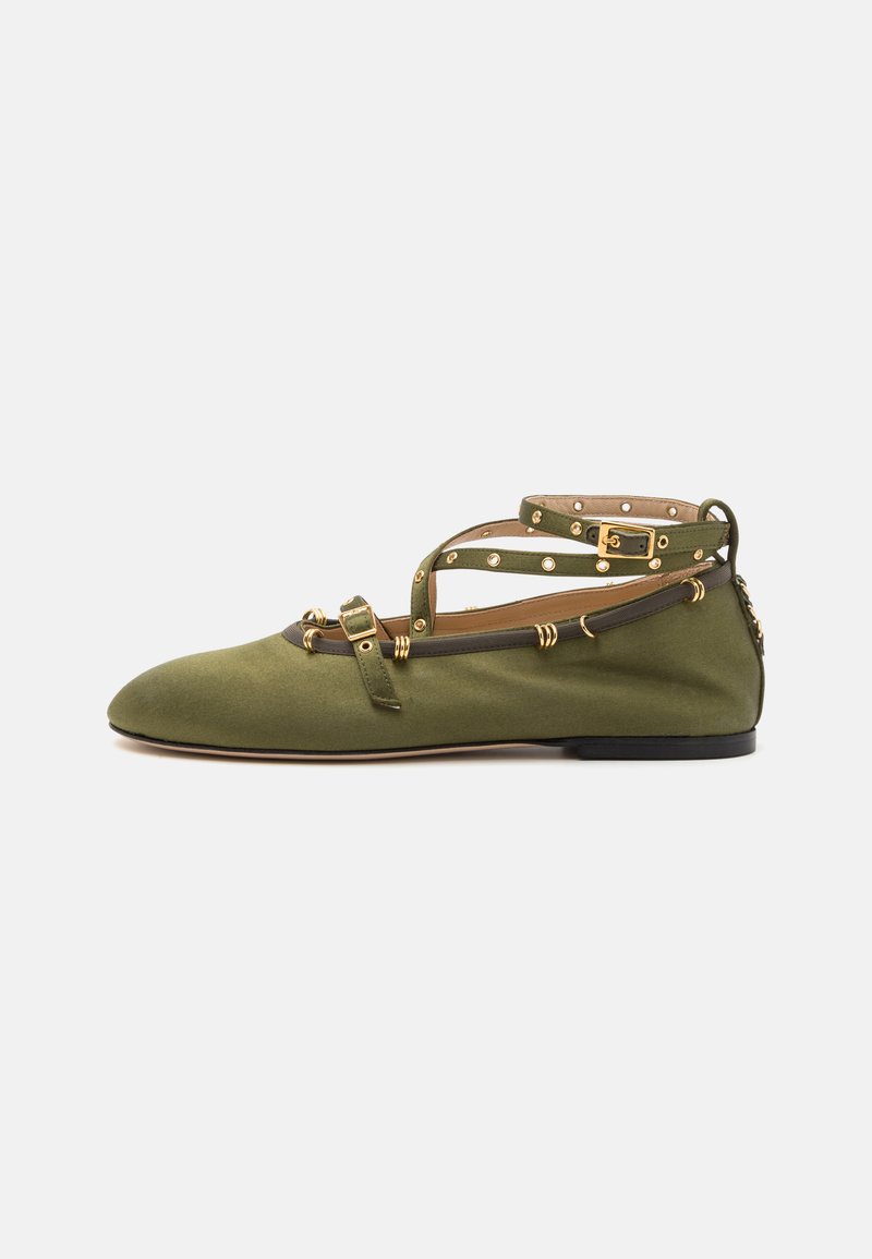 Green fabric ballet flat with a pointed toe, ankle straps, gold hardware accents, and a small black heel, featuring decorative studs.