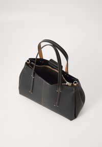 Borsa nera in tessuto con due manici, chiusura a zip e cuciture bianche a contrasto. L'interno presenta una fodera color tan e una piccola tasca.