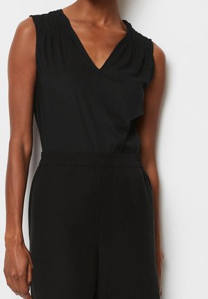 Zwart mouwloos topje met een V-hals, voorzien van geplooide details bij de schouders en een gladde textuur, gecombineerd met zwarte broek met hoge taille.